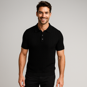 Man wearing a black polo shirt against a gray background