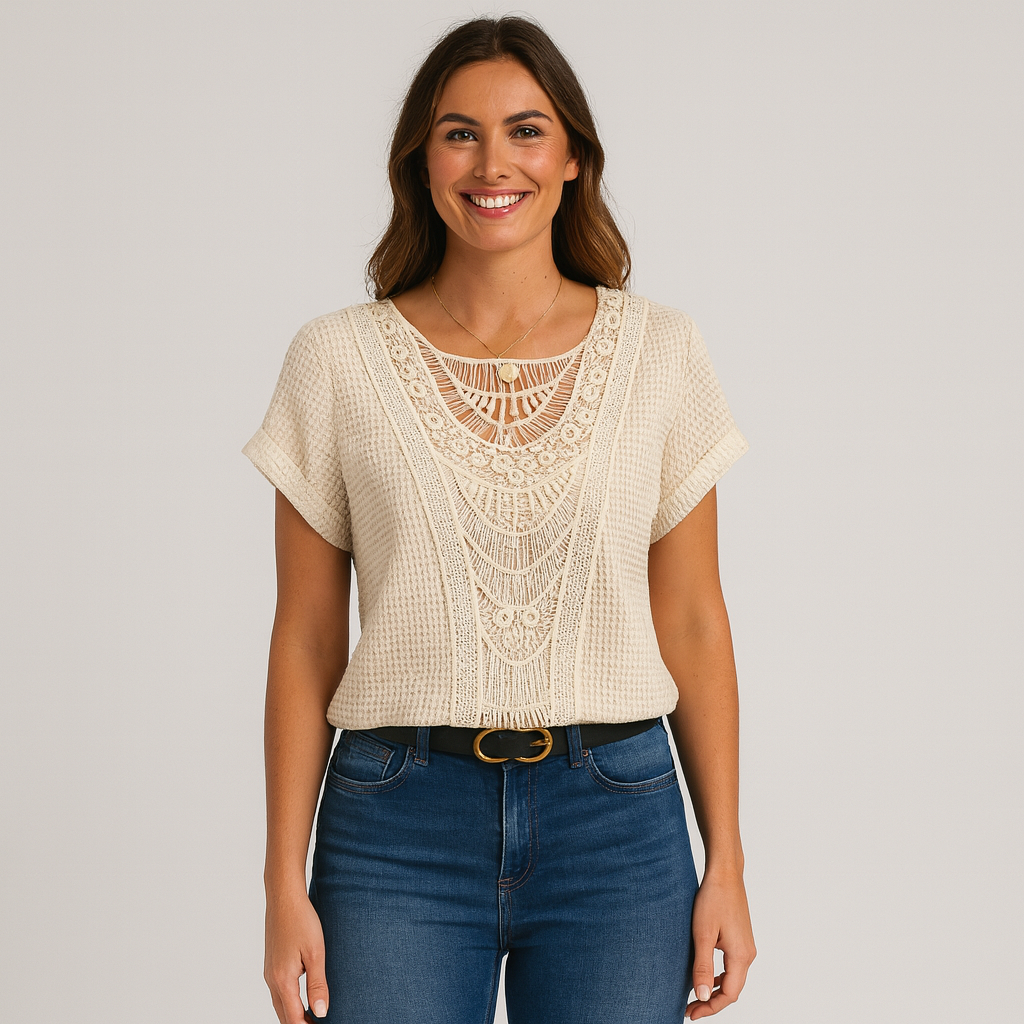 Woman wearing a beige lace top and blue jeans on a plain background
