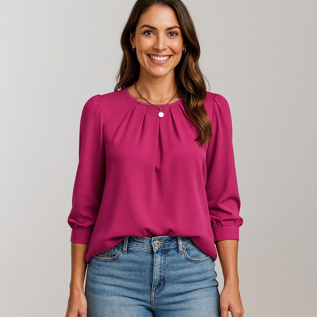 Woman wearing a pink blouse and blue jeans against a gray background